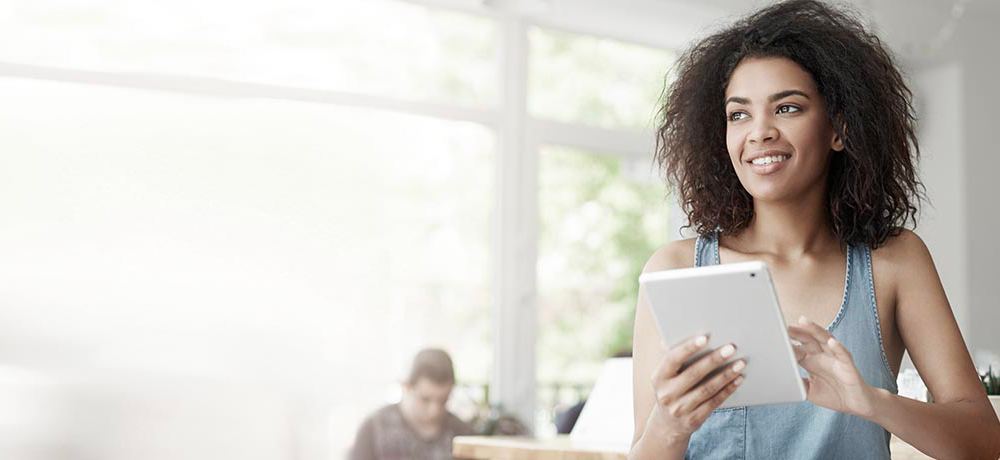 smiling woman reeding mail.com policies on tablet