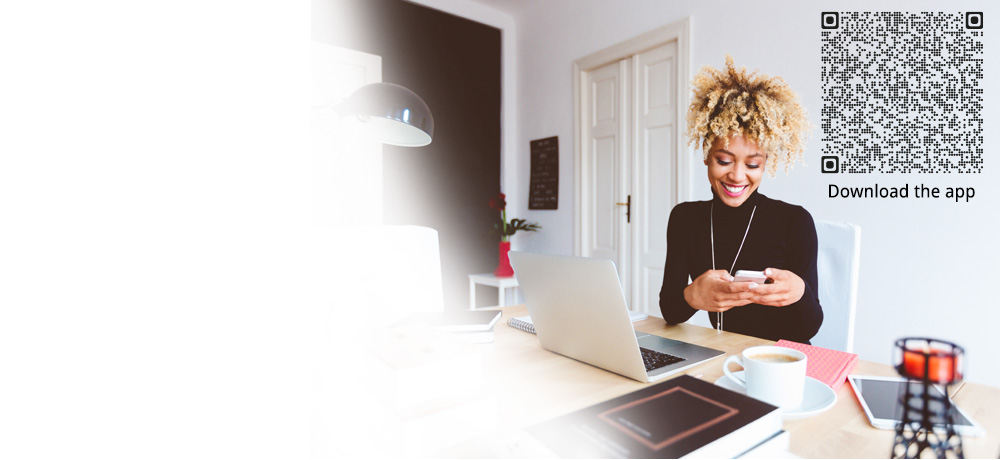 smiling woman with smartphone and laptop in her office