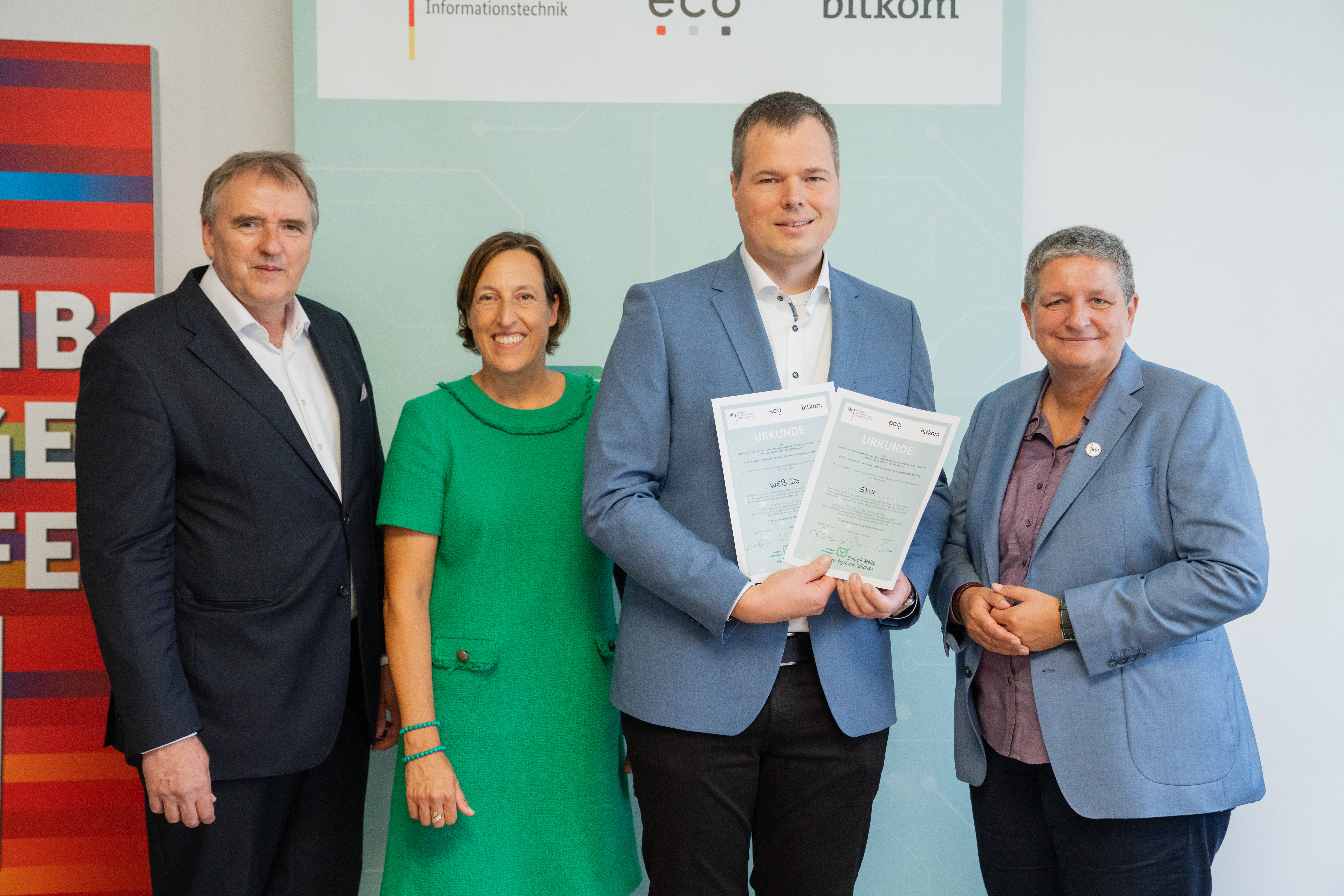 (v.l.) Prof. Norbert Pohlmann (eco-Verband), Susanne Dehmel (Bitkom) und BSI-Präsidentin Claudia Plattner (rechts) überreichen die Gold-Urkunden an Christian Kaspari von WEB.DE und GMX. (c) BSI