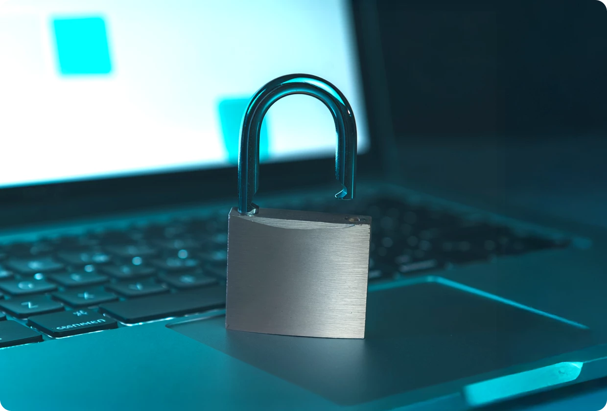 Ein offenes Vorhängeschloss steht auf einem geöffneten Laptop.