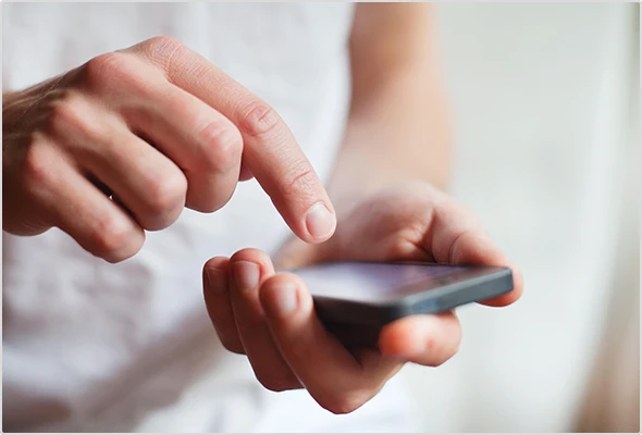 Person, die Handy in der Hand hält und darauf tippt.