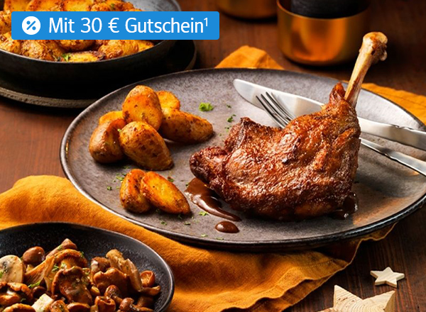 Gebratene Gänsekeule mit Bratkartoffeln und Pilzen auf festlich gedecktem Tisch.