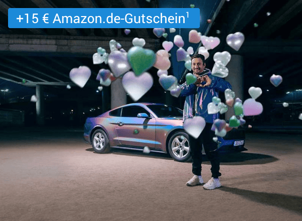 Mann steht neben silbernem Auto, umgeben von schwebenden Herz- und Sternsymbolen in verschiedenen Farben mit einem Text links oben der "+15 € Amazon.de Gutschein¹" lautet