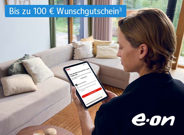 Vater und Sohn pflanzen einen Baum vor einem Haus mit Solarpanelen auf dem Dach, E.ON Logo und Hinweis 'Bis zu 50 Euro Wunschgutschein'