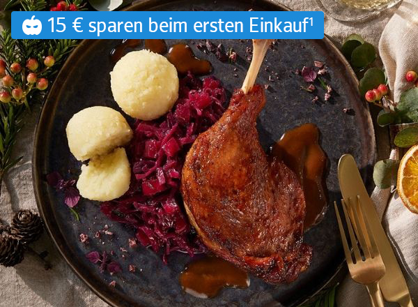 Zwei Personen feiern fröhlich beim Weihnachtsessen mit Wein und festlich gedecktem Tisch.