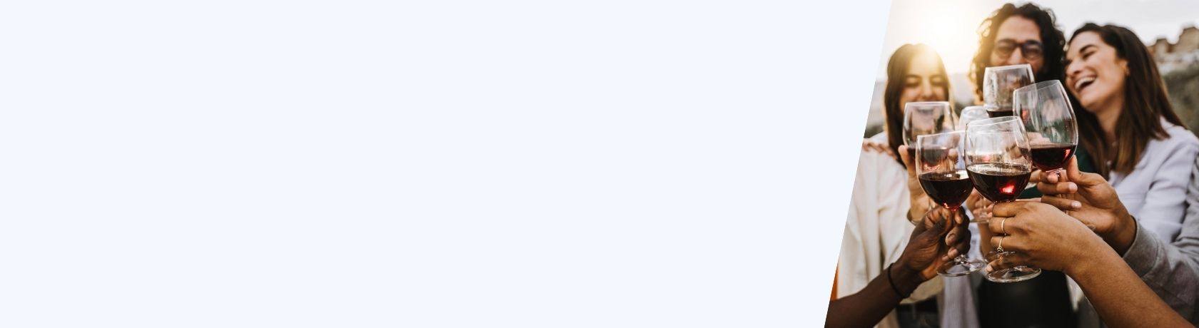 Menschen stoßen mit Rotweingläsern an, nur die Hände und Gläser sind scharf zu sehen.