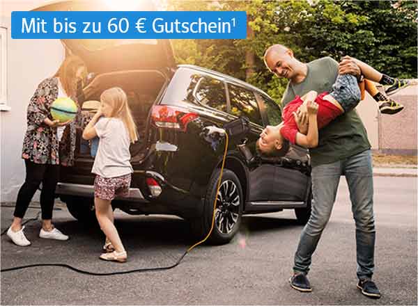 Ein Auto mit geöffnetem Kofferraum steht vor einem Haus. Eine Familie steht vor dem Auto. Die Mutter lädt Gepäck in den Kofferraum, ein Kind steht daneben. Der Vater steht scherzend mit einem weiteren Kind neben dem Fahrzeug.