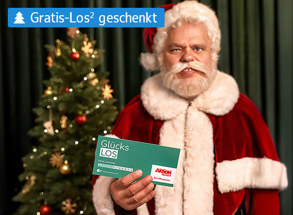 Person in rotem Weihnachtsmannkostüm hält ein grünes Los mit der Aufschrift 'Glücks LOS' vor einem geschmückten Weihnachtsbaum.