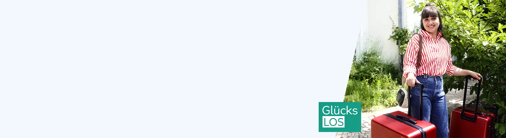 Frau mit rot-weiß gestreiftem Hemd und blauer Jeans zieht zwei Koffer, einen roten und einen schwarzen, vor weißer Wand