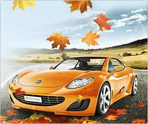 Ein orangefarbenes Auto fährt im Herbst über eine Landstraße, umgeben von buntem Laub und Natur.