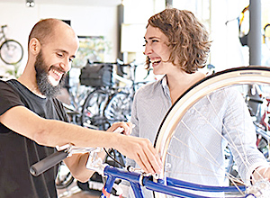 Fahrradversicherung: Fahrradhändler und Kundin im Verkaufsgespräch
